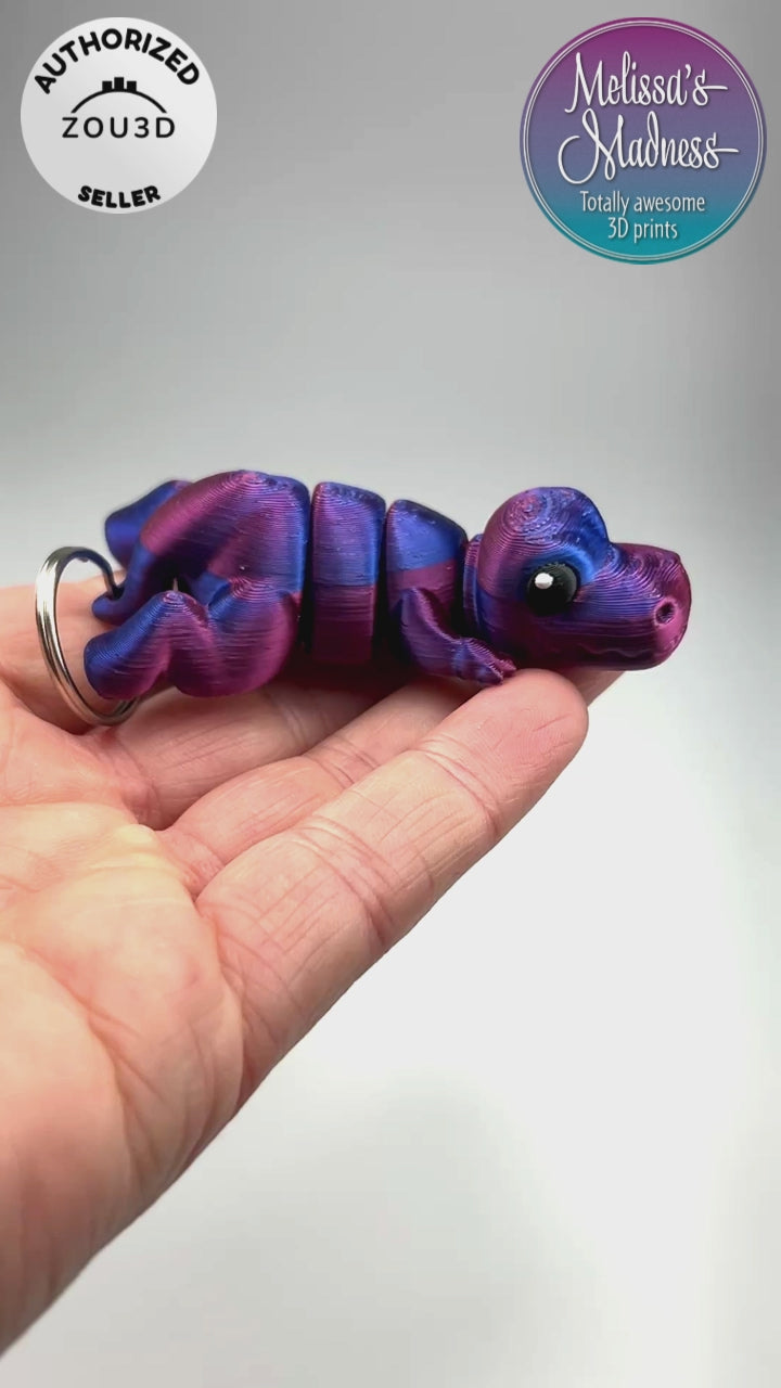 3D Printed Articulated Cute Tyrannosaurus Rex Chunky Keychain in Red+Blue Shifting Flexi Collector Item Showing Articulation and Flexibility