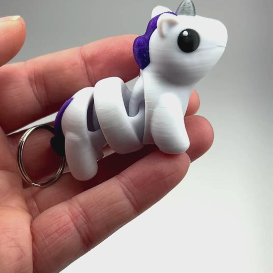 3D Printed Articulated Cute Unicorn Chunky Keychain in White, Witch's Brew, & Silver Flexi Collector Item Showing Articulation and Flexibility