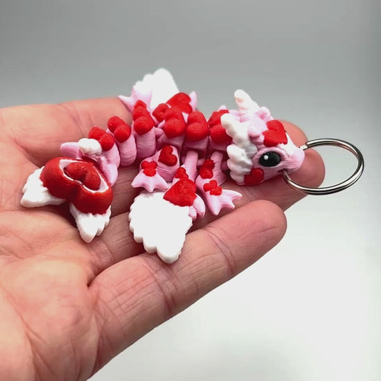Handcrafted Tiny Heart Dragon Keychain in Petal Pink & Red Articulated Figurine Made in Montana Demonstrating Joint Flexibility