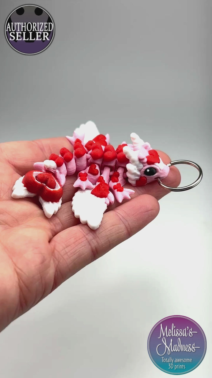 Handcrafted Tiny Heart Dragon Keychain in Petal Pink & Red Articulated Figurine Made in Montana Demonstrating Joint Flexibility